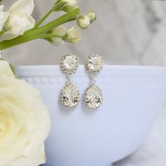 Glamorous and bold, The Sophia Earrings, are a stunning way to complete your wedding day look. Swarovski crystals and cubic zirconia come together in this modern earring perfect for a black tie wedding. Reminiscent of jewelry worn by celebrities, these earrings will be a jaw dropping complement to your wedding dress. Size - earring length is slightly shorter than 1.5", earring width is 0.5", top chaton is 8mm, and teardrop crystal is 14mm long. Materials - Swarovski crystals, cubic zirconia Meta Glamorous Diamond Earrings For Wedding, Glamorous Wedding Diamond Earrings With Diamond Accents, Glamorous Diamond Wedding Earrings, Glamorous Wedding Diamond Earrings With Accents, Glamorous Diamond Earrings With Sparkling Stones For Wedding, Glamorous Bridal Earrings With Diamond Accents For Anniversary, Glamorous Wedding Crystal Earrings With Diamond Accents, Wedding Cubic Zirconia Earrings With Diamond Accents, Classic Crystal Earrings With Diamond Accents For Wedding