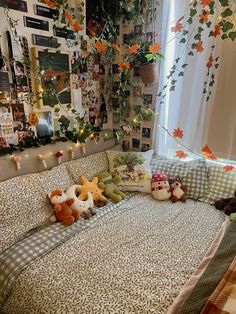 a bed with many stuffed animals on it in a bedroom next to a wall full of pictures