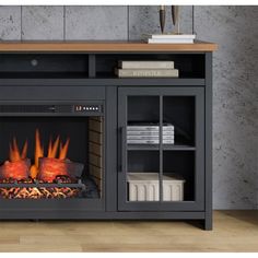 an entertainment center with a fire in the fireplace