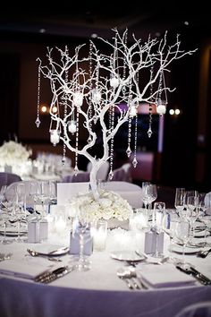 the centerpieces are decorated with white flowers and crystal beads, along with candles