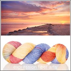 three skeins of yarn sitting next to each other in front of the ocean