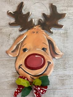 a reindeer head hanging on the wall with a red bow around it's neck