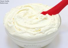 a white bowl filled with whipped cream and a red spoon