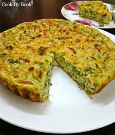 a quiche is cut into pieces on a white plate