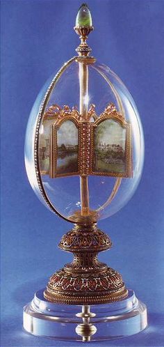 a glass ball with pictures inside it on top of a metal stand in front of a blue background