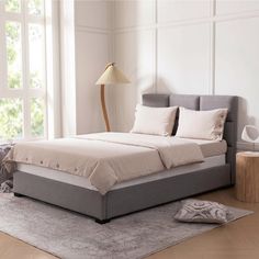 a large bed sitting on top of a hard wood floor next to a white wall