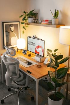 a desk with a computer, lamp and potted plant