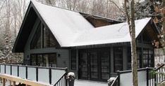 a house covered in snow next to trees