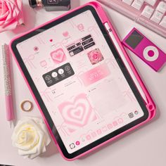 a pink tablet sitting on top of a white desk next to a keyboard and flower