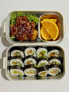 two metal trays filled with sushi and orange slices