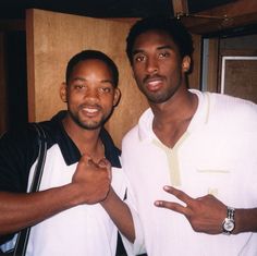 two men standing next to each other posing for the camera