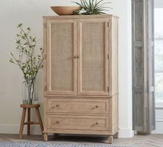 a wooden cabinet with plants on top and a potted plant sitting on top of it