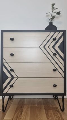 a black and white dresser with an arrow design on it