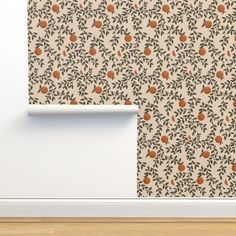 an orange and green wallpaper with leaves on it, next to a white door