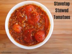 a white bowl filled with stew sitting on top of a wooden table