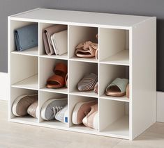 a white cubby filled with lots of shoes on top of a hard wood floor