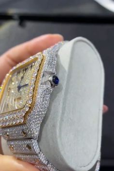 a person holding a watch in their hand with diamonds on the face and blue eyes