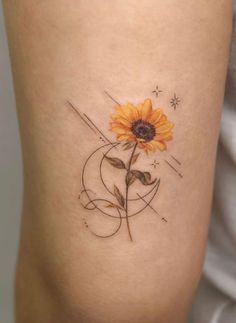 a small sunflower tattoo on the right side of the arm, with swirls and stars around it