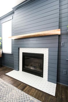 a living room with blue walls and a fireplace in the center, along with a rug on the floor