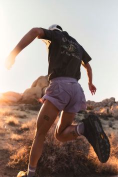 a person jumping in the air with a baseball glove on their hand and wearing shorts