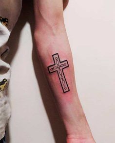 a person with a cross tattoo on their arm