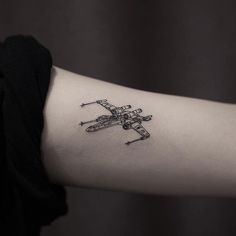 a small airplane tattoo on the arm