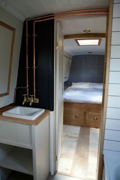 a bathroom with a sink, mirror and bed in the back ground area is shown