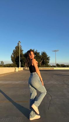 a woman standing in an empty parking lot