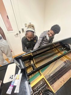 two men looking at musical instruments on a table