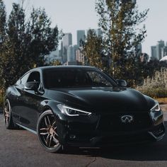 a black sports car parked in front of a city