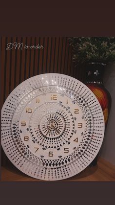 a white plate sitting on top of a wooden table next to a vase with flowers