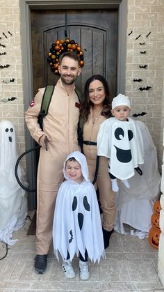 a man and woman in halloween costumes standing next to a child