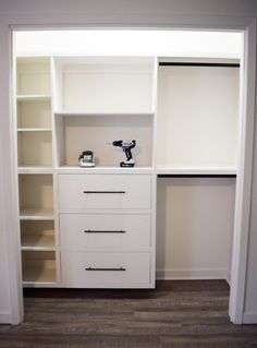 an empty closet with white shelves and drawers on the wall next to a pair of drillers