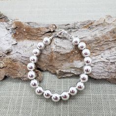 "Very pretty! Classic everyday wear sterling silver beaded bracelet. All shiny, round ball 8mm sterling silver beads. 🚩 IMPORTANT IMPORTANT 🚩 These are LARGE beads. The INSIDE circumference of this bracelet causes it to fit snug compared to smaller bead bracelets. Length measured from clasp to ring - NOT bead to bead - See next to last photo 🔸🔶 MEASURE WRIST: wrap soft measuring tape around wrist (not tight) - See last photo. Suggest adding at least 3/4\" - 1\" depending on your preferred sn Small Bead Bracelet, Large Beads, Sterling Silver Bead Bracelet, Silver Bead Necklace, Silver Bead Bracelet, Toggle Bracelet, Silver Bead, Measuring Tape, Matching Necklaces