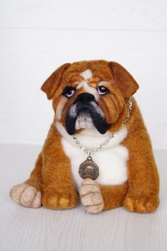 a brown and white stuffed dog sitting on top of a table next to a wall