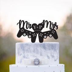 a close up of a wedding cake topper with two butterflies on it and the words mr and mrs spelled in cursive font