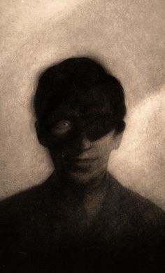 a black and white photo of a person with their face obscured by the shadow of another person's head