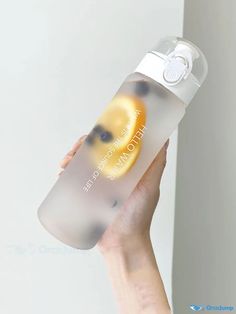 a hand holding a water bottle with an orange on it