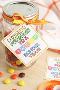 a jar filled with candy sitting on top of a table next to other candies