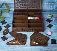 an open wooden box with crayons in it on a blue table next to other items