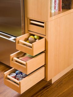 an open drawer in a kitchen next to a refrigerator