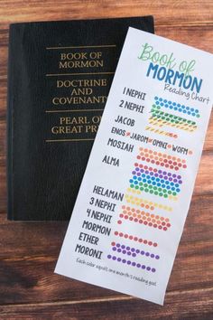 the book of mormon is next to a black and white book with colored dots on it