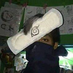 a young boy is hiding behind a large pillow with an eye patch on it's forehead