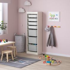 a child's room with pink walls and toys on the floor in front of it