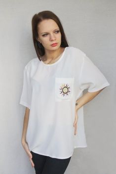 "Classic back button blouse with embroidered sun and what looks like a compass on chest pocket, has slits on both sides of the blouse. On the ends of the sleeves there are two narrow lines embroidered with golden thread. In great vintage condition. Measured laying flat - double for circumference: From armpit to armpit: 22.4\" (57 cm) Length: 28\" (71 cm) Sleeve's length: 9.8\" (25 cm) Tag: YESSICA, tagged as size 44 Model in the photos is size S More from Vintage Finds: https://www.etsy.com/shop/somethingmustbehere We also make linen, knit and crochet items: https://www.etsy.com/shop/ActLikeACharm" Summer Beach Blouse With Pockets, Oversized Embroidered Summer Blouse, Back Button Blouse, Sun Embroidery, Embroidered Sun, Golden Thread, Women Shirt Top, Button Blouse, Summer Blouse