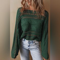 a woman wearing a green sweater and jeans