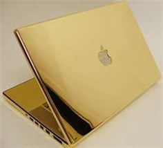 an apple laptop computer sitting on top of a white table next to another gold macbook