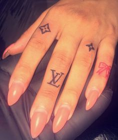 a woman's hand with two small tattoos on her fingers and the letter y