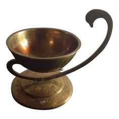 a metal bowl with an ornate handle on top