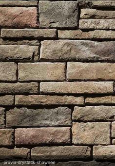 a brick wall made out of several different types of stone blocks, including brown and tan